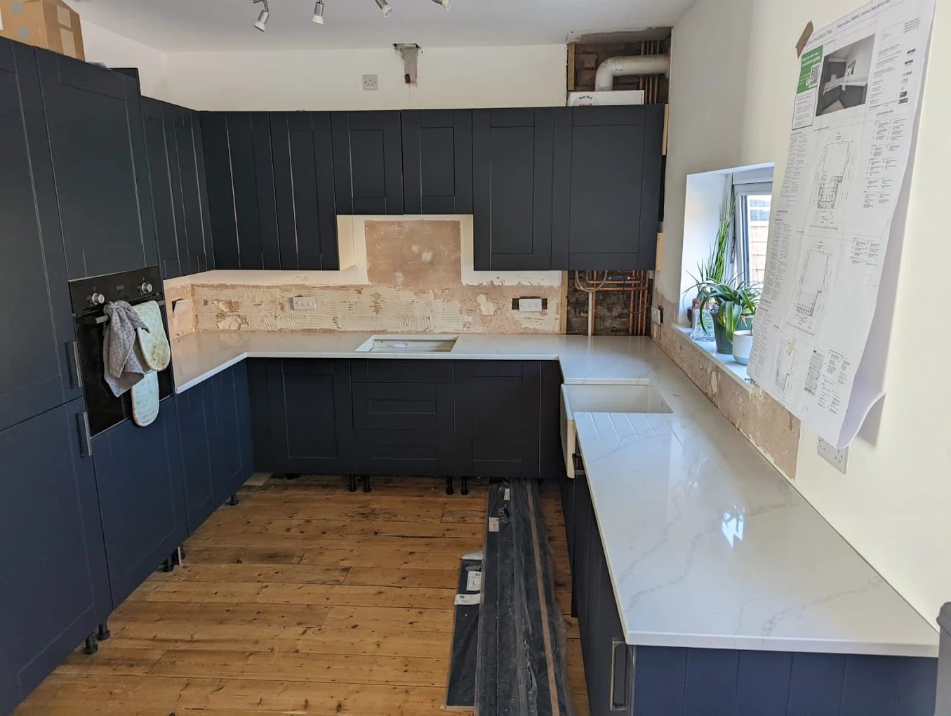 Fitted kitchen with navy cabinetry and marble worktops installed in Cullompton